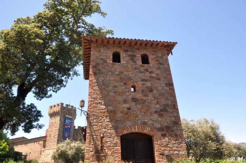 Castello Di Amorosa: каменная башня с арочным входом и узкими окнами